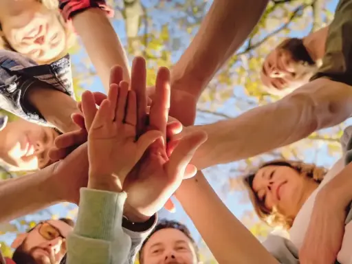 Grupa ludzi zjednoczona w geście solidarności. To przykład altruizmu, co to znaczy pomagać sobie nawzajem.