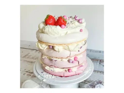 Eine mehrstöckige Baiser Torte mit Sahne, Erdbeeren und rosa Zuckerperlen.