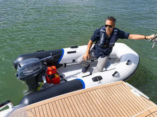 Un homme en gilet de sauvetage dans un semi-rigide, prêt à partir avec le moteur bateau 6cv le plus puissant.