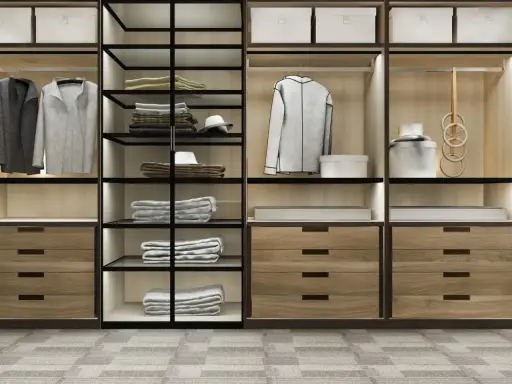 Un moderno armario empotrado con puertas de cristal y madera, organizado con ropa doblada, colgada y accesorios.