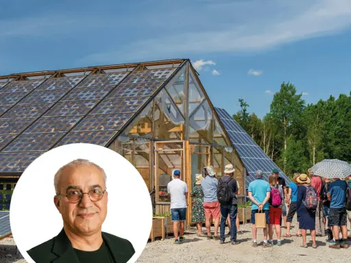 En grupp besökare tittar på ett växthus med solpaneler på taket, en del av auterra solar-projektet.