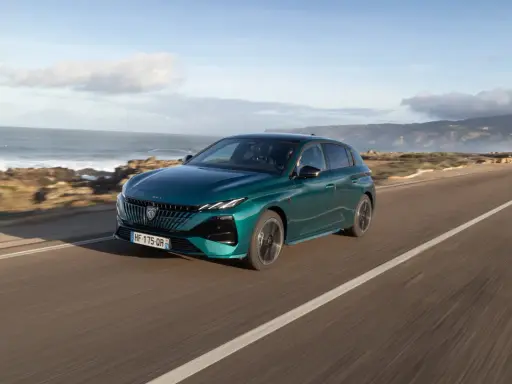 Zielony Peugeot 308 jedzie wzdłuż malowniczego wybrzeża.