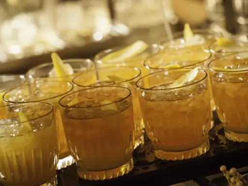 Mehrere Cognac Cocktails mit Eis und Zitronenzeste, bereit zum Servieren.