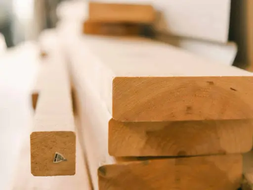 Stapel von unbehandelten Holzbrettern, bereit für den Bau eines Dach-Ringbalkens.