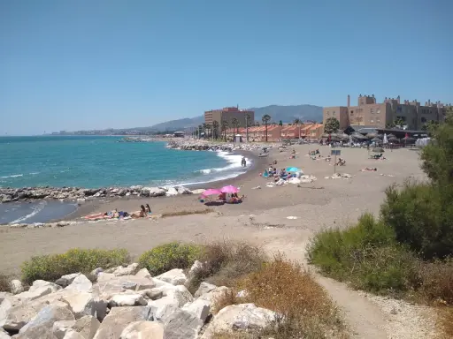 Sonniger Tag am playa de guadalmar mit Menschen, die sich am Strand sonnen und im türkisfarbenen Meer schwimmen.