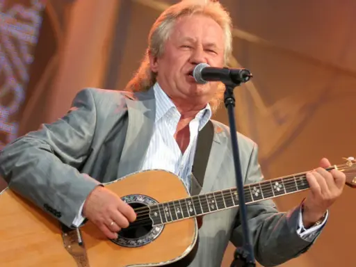 Artysta w szarym garniturze gra na gitarze i śpiewa. Kto śpiewał kolorowe jarmarki?