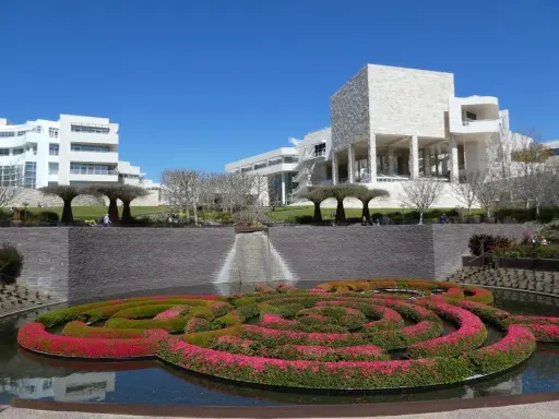A vibrant floral maze floats in a pool before the modern architecture of the Los Angeles Center for Digital Art.