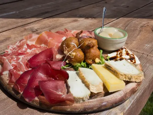 Tagliere con salumi, formaggi, frittelle e cipolline, un assaggio dei piatti tipici Valtellina.
