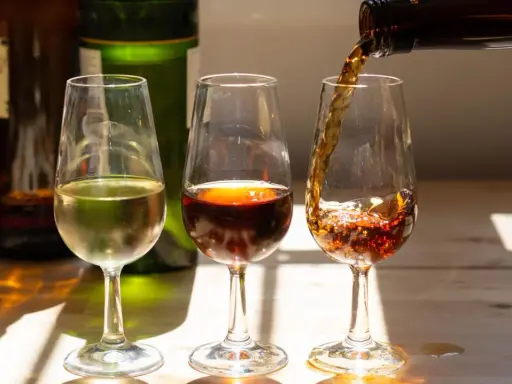 Drei Gläser mit Sherry, die die Vielfalt der sherry Herkunft zeigen. Ein helles, ein dunkles und ein drittes, das gerade eingeschenkt wird.