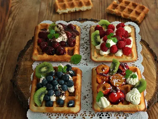 Pyszne gofry belgijskie z owocami: malinami, borówkami, kiwi i śliwkami. Idealne na deser, gdy szukasz inspiracji na gofry belgijskie przepis.