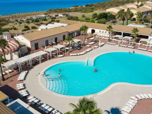 Vacanze al Sikania Eco Resort: piscina azzurra, lettini, palme e il mare all'orizzonte.
