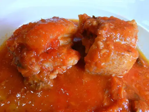 Succulento spezzatino di maiale in salsa rossa, un piatto che profuma di casa e tradizione.