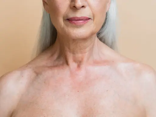 Gros plan sur le décolleté d'une femme âgée, montrant les marques du temps et les dégâts du soleil sur la peau.