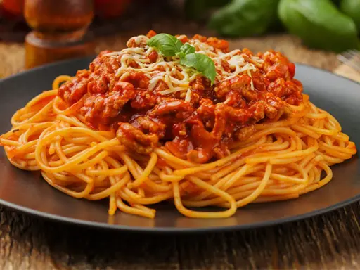 Pyszne spaghetti bolognese z mielonym mięsem, polane sosem pomidorowym i posypane serem. Idealne pytanie: jakie mięso do spaghetti?