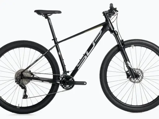 Czarny rower górski, idealny do wyścigów mtb xc. Wyposażony w amortyzator, przerzutki i opony CST Jack Rabbit.