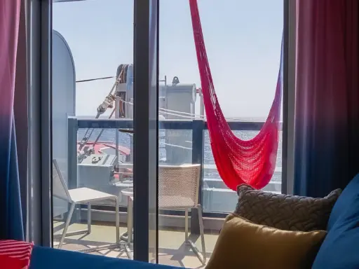 Cabina balcone vista parziale MSC con amaca rossa e cuscini accoglienti.