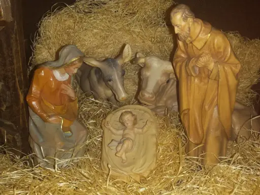 Szopka z figurkami: Maryja, Józef, Dzieciątko Jezus, wołek i osiołek. Tekst opowiada o narodzinach.