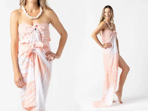 Modella mostra come indossare un pareo con fantasia tropicale, annodato in vita e al seno, con una collana di conchiglie.