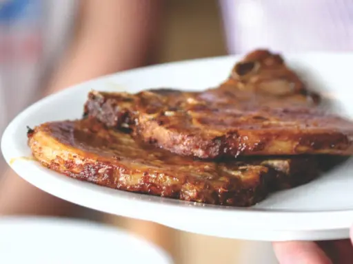 Dos jugosas chuletas de cerdo a la parrilla, doradas y listas para disfrutar.