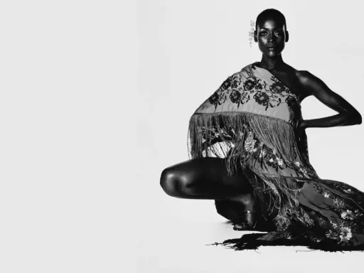 Irving Penn captura a una modelo agachada con un chal bordado y flecos.