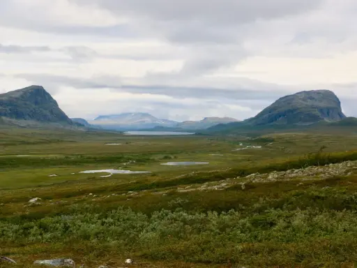 Vast, green valley with mountains and lakes, perfect for hiking trails Sweden.