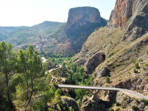 Un puente cruza un cañón con un pueblo en la ladera. El **mirador del infierno** ofrece vistas espectaculares de la garganta y las montañas.