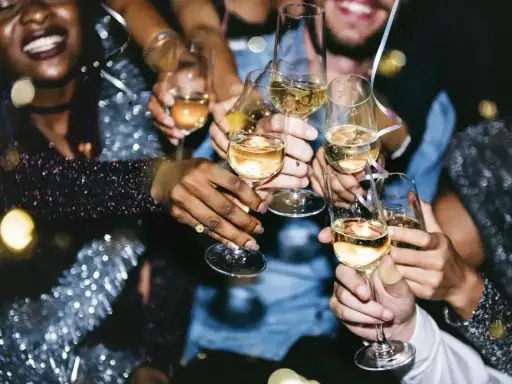 Radosna impreza, ludzie wznoszą kieliszki z szampanem. Po spożyciu alkoholu, pobranie krwi może dać inne wyniki.