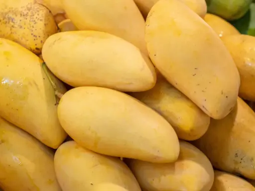 Stos dojrzałych, żółtych mango. Warto sprawdzić mango indeks glikemiczny przed spożyciem.