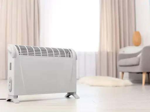 Ein weißer Elektroheizer steht im Wohnzimmer. Er hilft, die strom heizung kosten pro monat im Blick zu behalten.