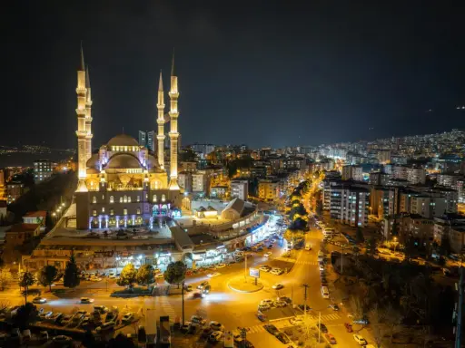 Piękny meczet nocą, oświetlony i otoczony miastem. Warto wiedzieć, ramadan co to za święty czas.
