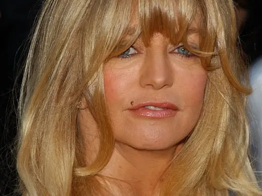 Goldie Hawn ler mot kameran, hennes blonda hår faller runt ansiktet. Tänker på alla roliga filmer med Goldie Hawn.