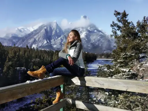 Ragazza con gita outfit montagna estate, gode del panorama innevato.