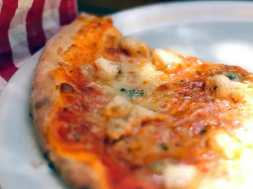 Tranche de pizza appétissante sur une assiette blanche, avec une serviette à carreaux rouges et blancs. Une recette parfaite avec de la farine sans gluten pour pizza.