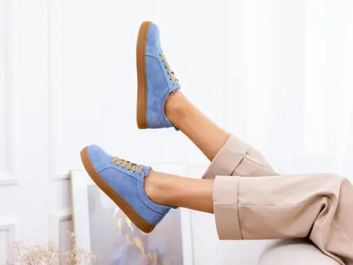 Niebieskie buty z nubuku, jak odnowić je, by wyglądały jak nowe. Stylowe sneakersy na brązowej podeszwie.