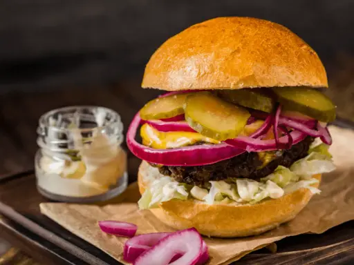 Pyszny burger z soczystą wołowiną, chrupiącą sałatą, piklami, czerwoną cebulą i majonezem. Idealny na prawdziwe burgery przepis.