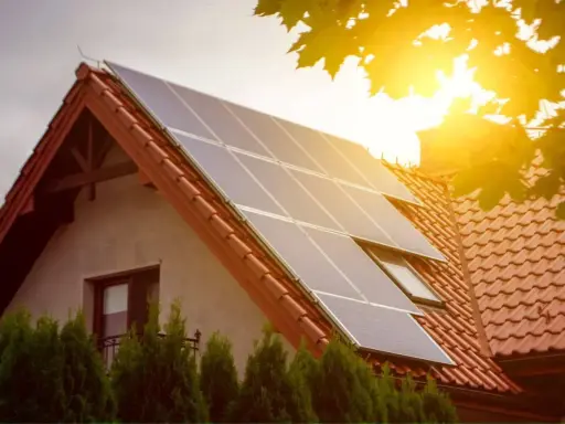 Panele słoneczne na dachu domu łapią promienie słońca, zapewniając czystą energię.