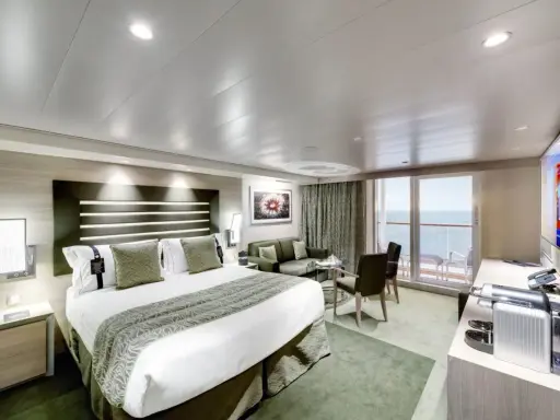Lussuosa cabina nave con letto king-size, divano, balcone vista mare e TV.