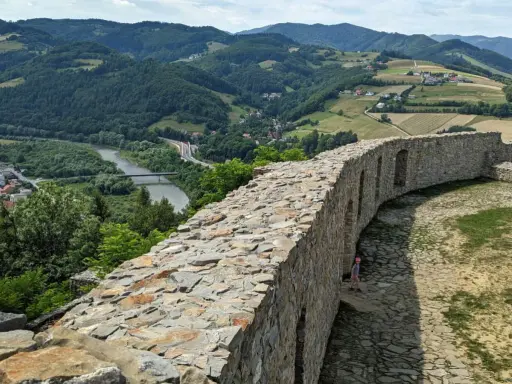Kamienne mury zamku w Rytrze, z których roztacza się widok na dolinę Dunajca i okoliczne wzgórza. To wspaniałe **rytro atrakcje** dla miłośników historii i przyrody.