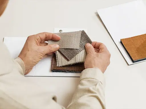 Hands examine fabric swatches, selecting the perfect butterfly lining for a project.