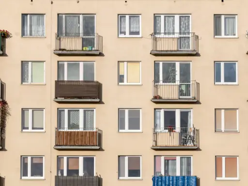 Façade d'immeuble avec de nombreux balcons et fenêtres, offrant un aperçu de la vie quotidienne et du **logement décent**.