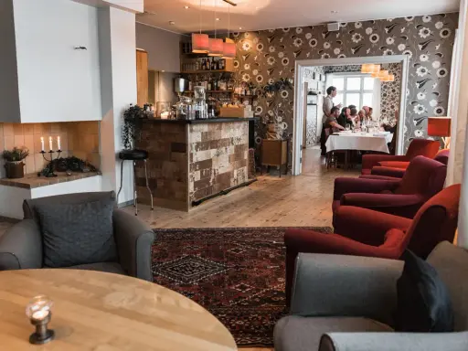 Mysig interiör på meteorologen ski lodge med öppen spis, bar och gäster som äter middag.