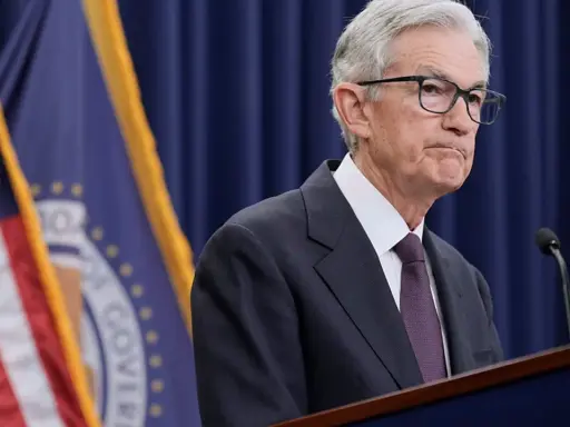 Jerome Powell przemawia na tle flag USA i Rezerwy Federalnej, instytucji, która budzi pytania, czy fed jest prywatny.