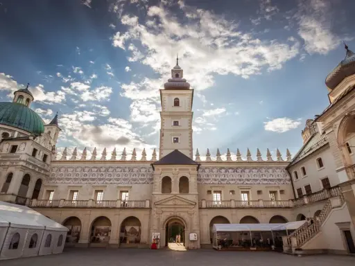 Piękny dziedziniec zamku Krasiczyn zachęca do zwiedzania. Architektura zachwyca pod błękitnym niebem.