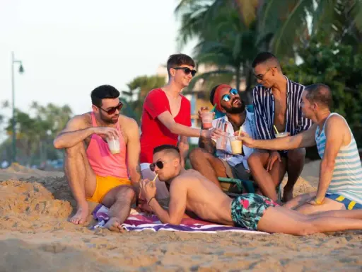 Friends enjoy drinks on the beach, a perfect day at a San Juan gay resort.