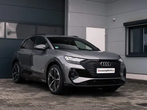 Grauer Audi q4 e tron steht vor einer Garage.