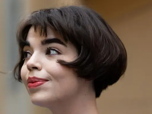Ein kurzer Bob mit leichten Wellen, der ihr Gesicht umrahmt. Perfekt gestylt für einen mühelosen Look.
