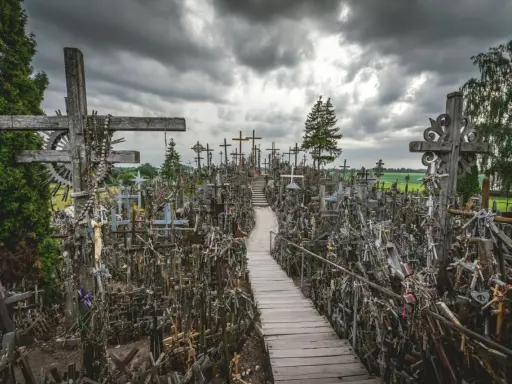 Enorm korskullen i Litauen, fylld med tusentals kors av trä och metall. En stig leder genom den imponerande samlingen.