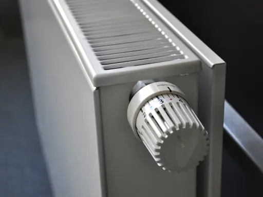 Biały grzejnik aluminiowy z termostatem. Dowiedz się, jak wyczyścić grzejnik aluminiowy w środku, by działał sprawniej.