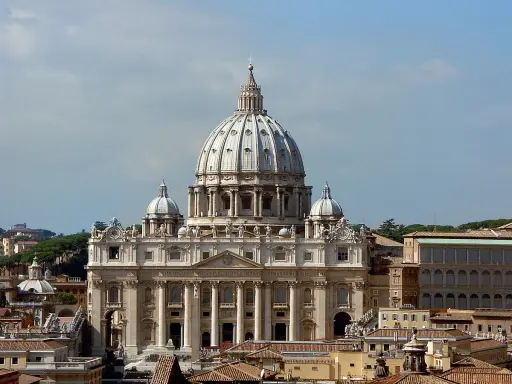 La majestueuse hauteur de la basilique Saint-Pierre domine le ciel romain, ses dômes imposants se détachant sur un ciel bleu clair.