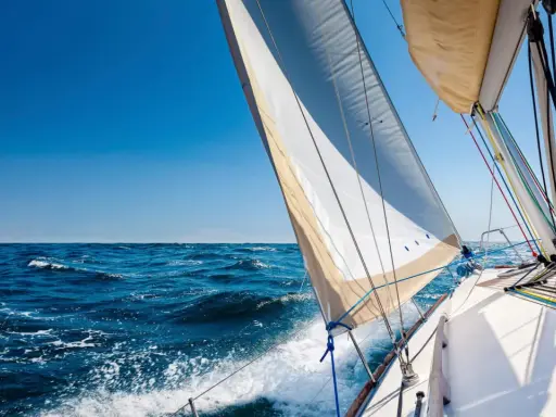 Segelboot gleitet über das Meer, das Takelage schiff ist gut sichtbar, blauer Himmel und Wellen.